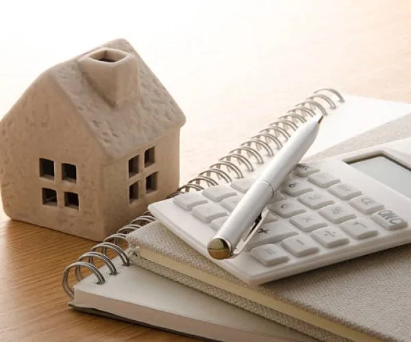 Toy house and calculator on the table